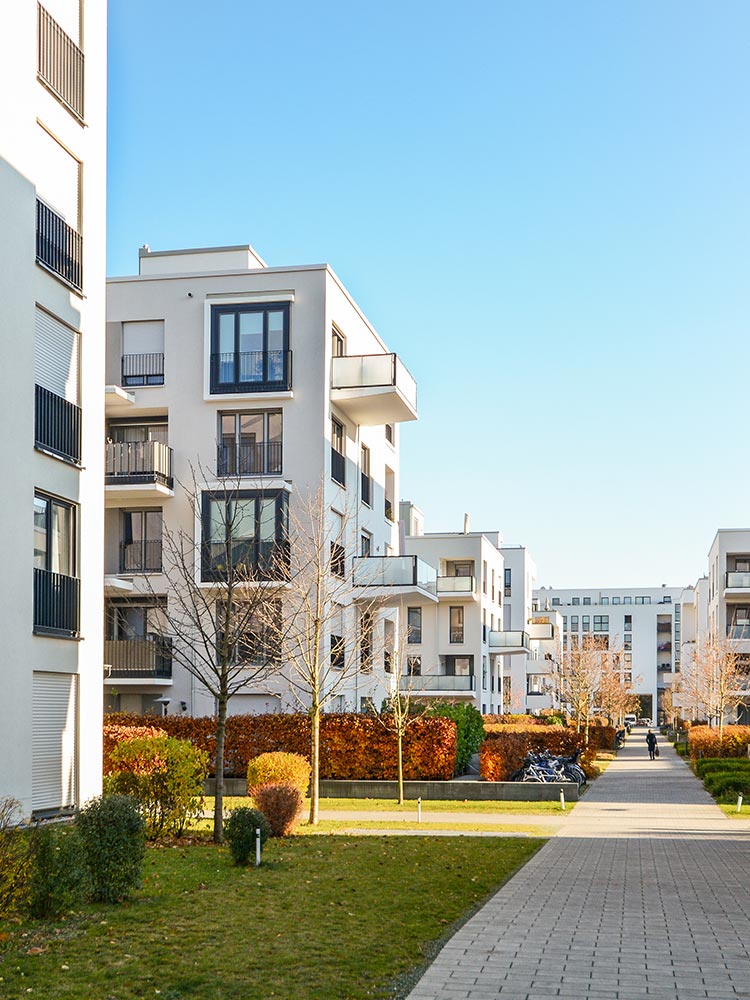 Modern multiplex buildings with multiple units, contemporary design, and shared communal space, representing compact and diverse missing middle housing.